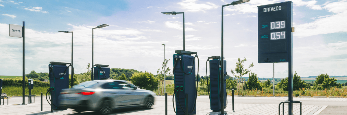 Une voiture électrique passe devant une station de recharge DRIVECO