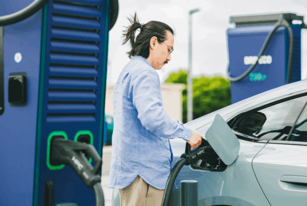 Un utilisateur de véhicule électrique branche un connecteur d'une station de recharge DRIVECO sur sa voiture.