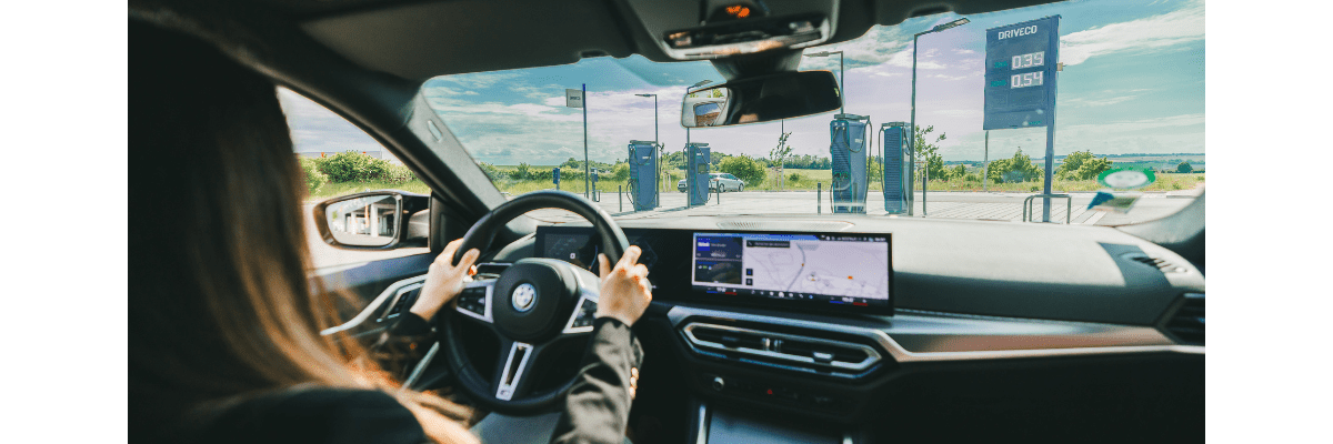 L'intérieur d'une BMW i4 100% électrique, devant une station de recharge électrique DRIVECO