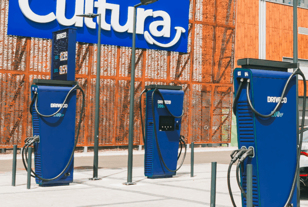 Trois bornes de recharge rapide DRIVECO de 200 kW installées sur le parking d’un magasin Cultura, avec affichage des tarifs sur un panneau digital.