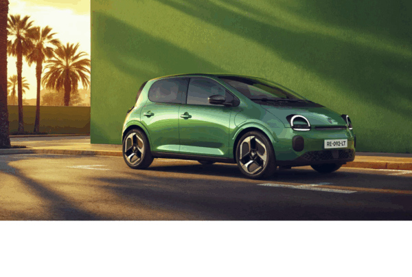 Une petite Twingo E-tech est garée le long d’une rue ensoleillée. Elle est photographiée de profil, avec des jantes noires modernes et des phares avant arrondis.