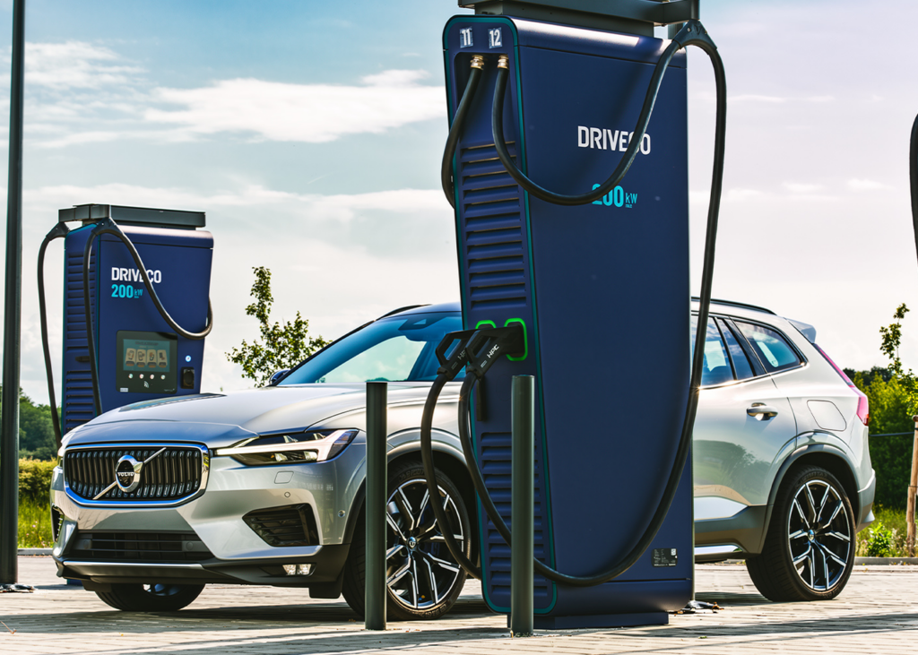 Une voiture électrique Volvo argentée en cours de recharge sur une borne de recharge rapide DRIVECO de 200 kW en extérieur.