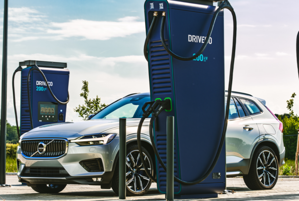 Une voiture électrique Volvo argentée en cours de recharge sur une borne de recharge rapide DRIVECO de 200 kW en extérieur.