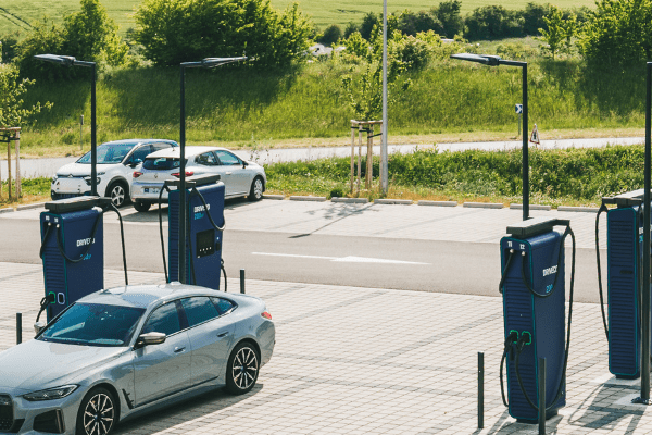Station de recharge électrique DRIVECO avec bornes rapides et voiture électrique en charge sur un parking extérieur