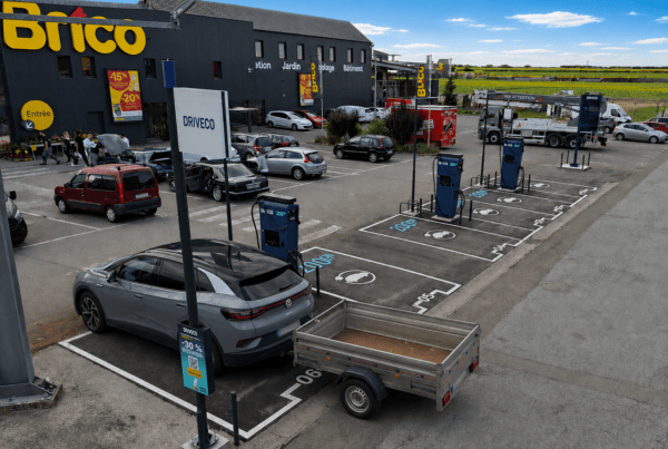 Un véhicule électrique tirant une remorque est stationné sur une place de borne de recharge électrique DRIVECO